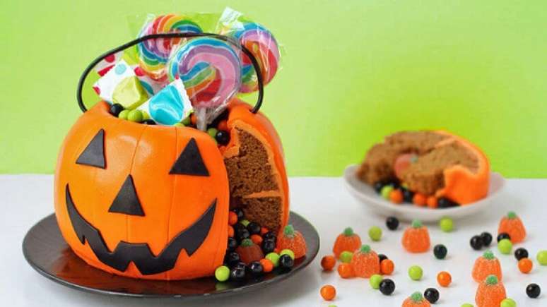 13. Bolo de Halloween em formato de abóbora serve de suporte para doces. Fonte: Pinterest