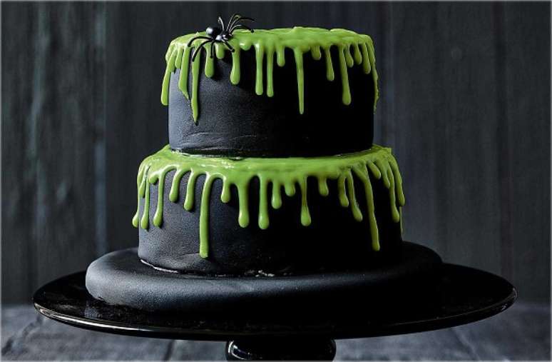 78. Bolo de Halloween com massa preta e cobertura verde com aranha. Fonte: Pinterest