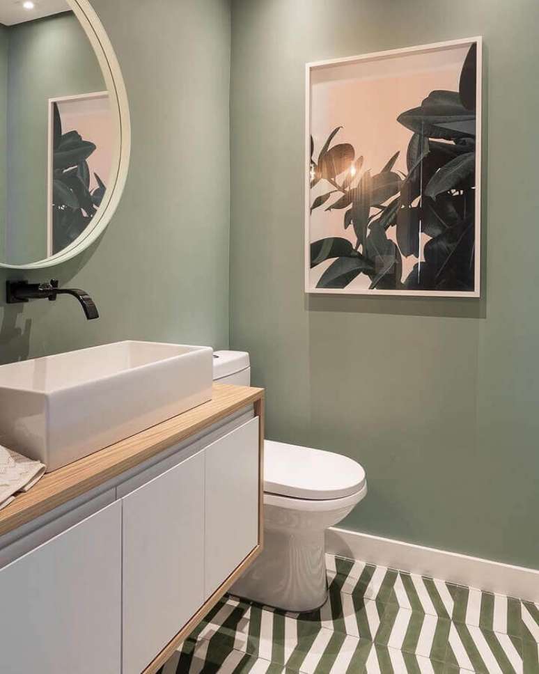 42. Decoração para banheiro pequeno com parede verde musgo e espelho redondo – Foto: Maurício Arruda