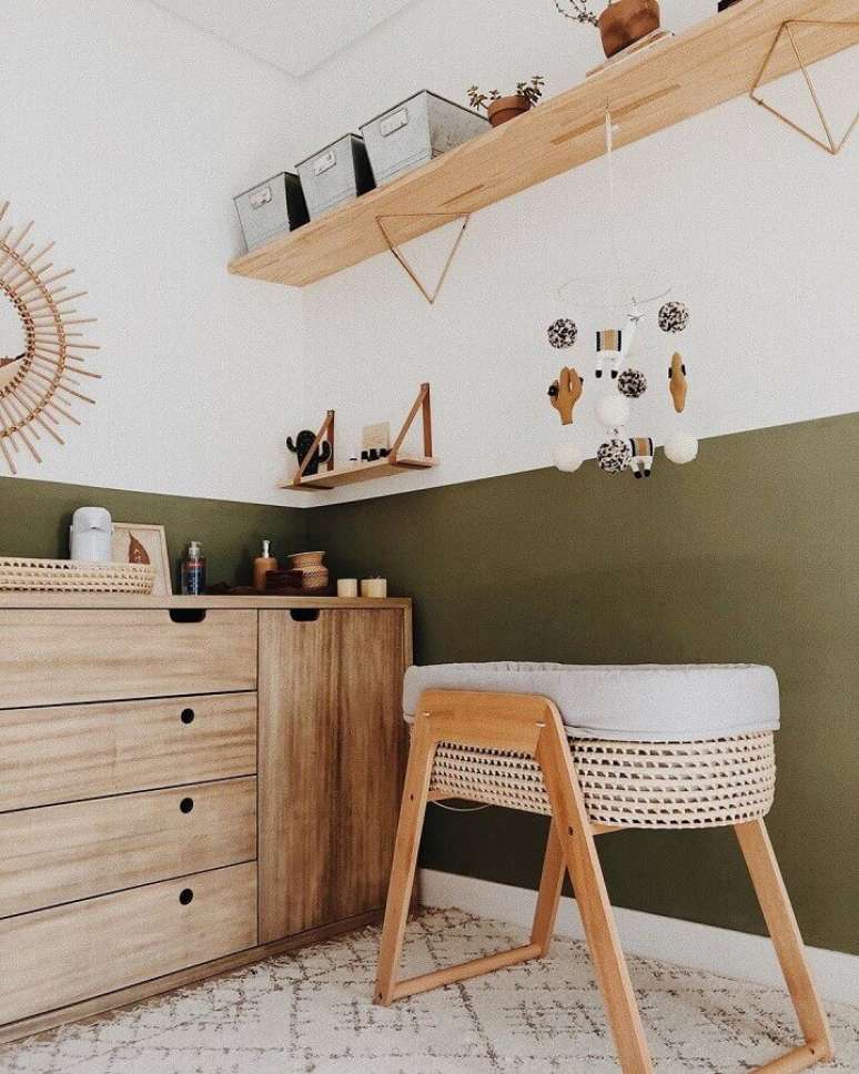 47. Decoração para quarto de bebê simples com móveis de madeira e parede verde musgo – Foto: Paloma Christiansen