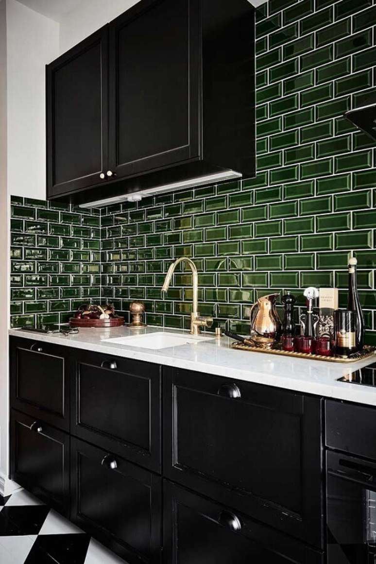 51. Cozinha planejada com armários pretos e revestimento verde musgo – Foto: Planeta Deco