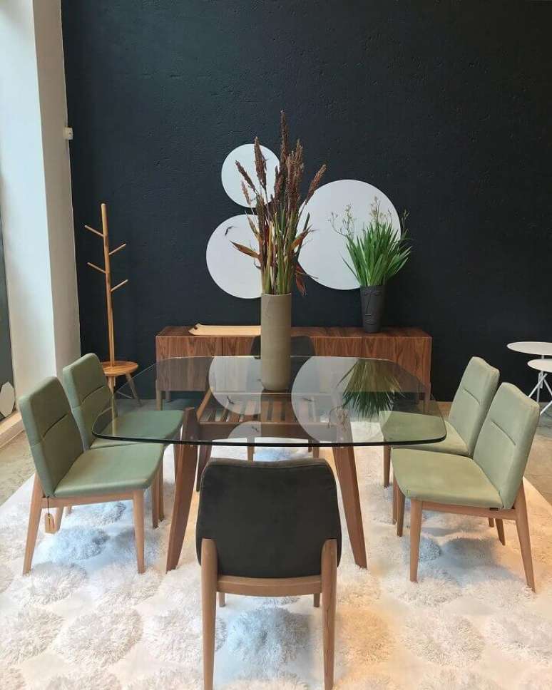 54. Sala de jantar moderna decorada com espelhos redondos em parede preta e cadeiras verde musgo para mesa de vidro – Foto: Gabriela Toledo Arquitetura