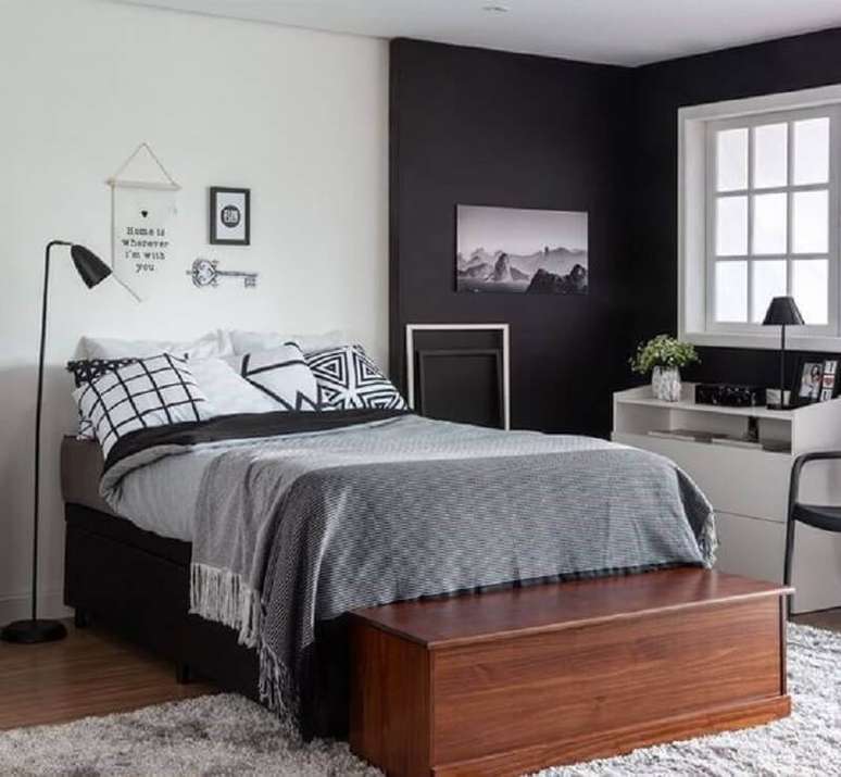 15. Decoração com cama box solteiro e baú de madeira para quarto moderno com parede preta – Foto: Compre VC