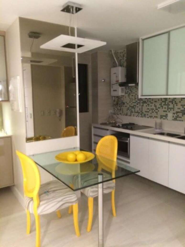 25. A cozinha planejada é linda com as cadeiras coloridas amarelas – Por: Caroline Guerra