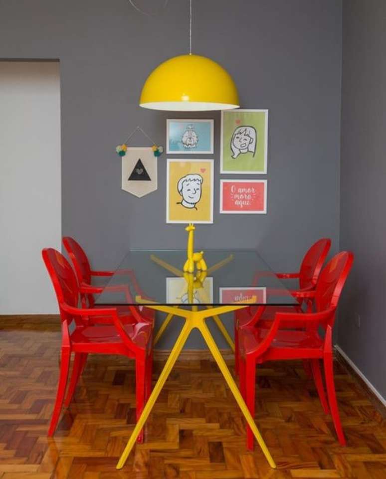 41. A sala cinza ganha destaque com a mesa de jantar com cadeiras coloridas vermelhas – Por: Pinterest