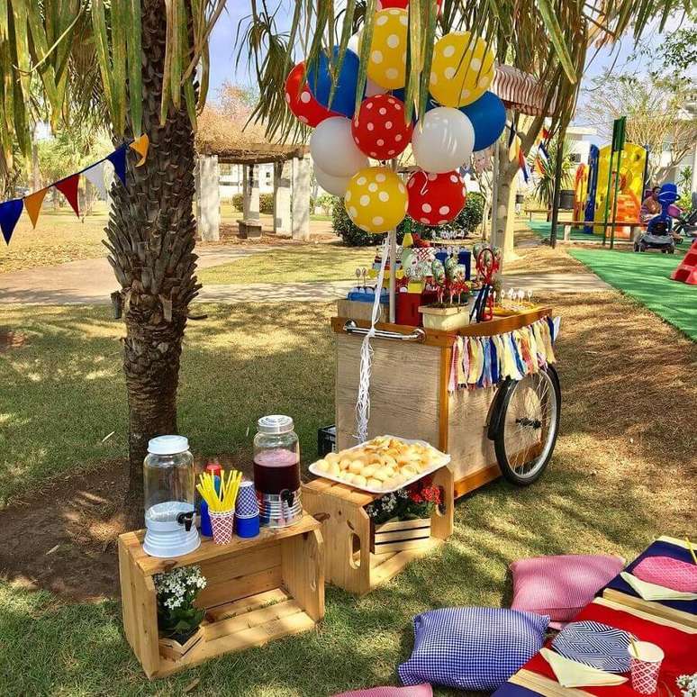 69. Decoração rústica para festa picnic com balões e almofadas coloridas e caixotes de madeira – Foto: Daniela Chiessi