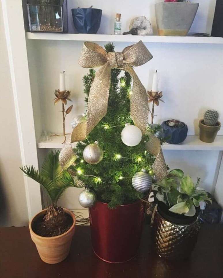 14. Ideia simples de árvore de Natal pequena decorada com bolas e laço dourado – Foto: Tiara Hale