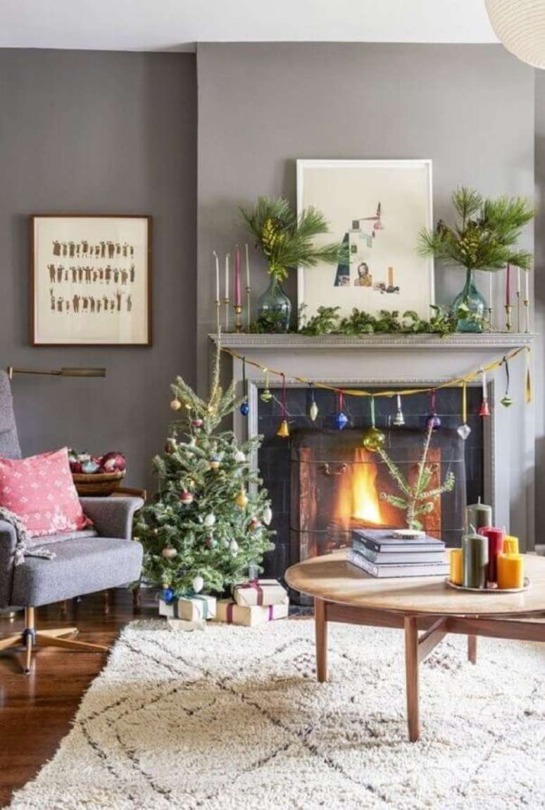 31. Decoração para sala de estar cinza com lareira e árvore pequena de Natal decorada – Foto: Pinterest