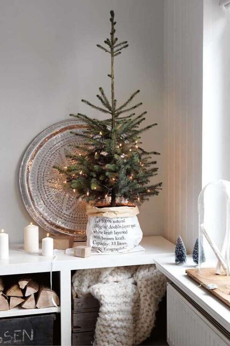 40. Decoração estilo escandinava com árvore de Natal pequena decorada com pisca pisca e suporte rústico – Foto: Homelovr