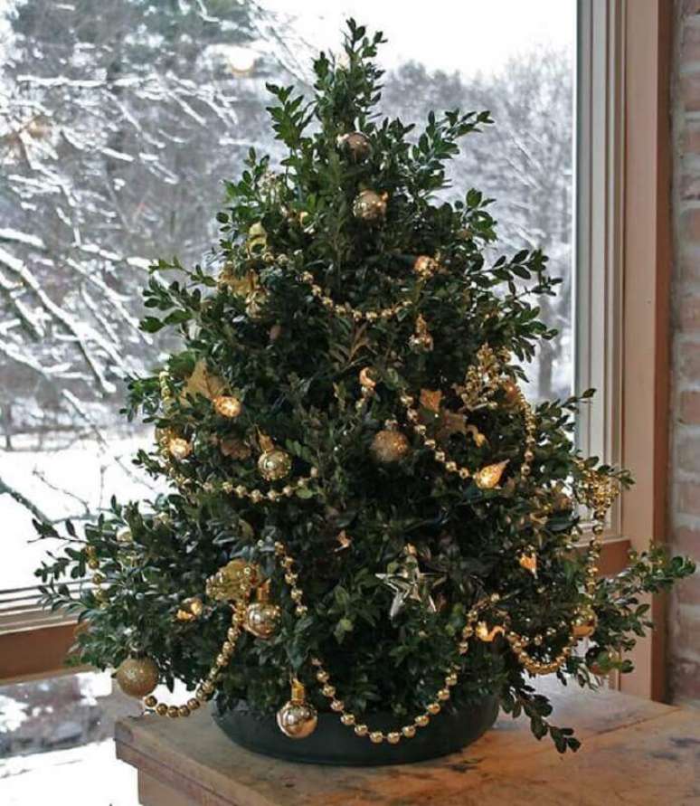 47. Enfeites dourados para uma decoração tradicional de árvore de Natal pequena – Foto: Kelly Bernier Designs