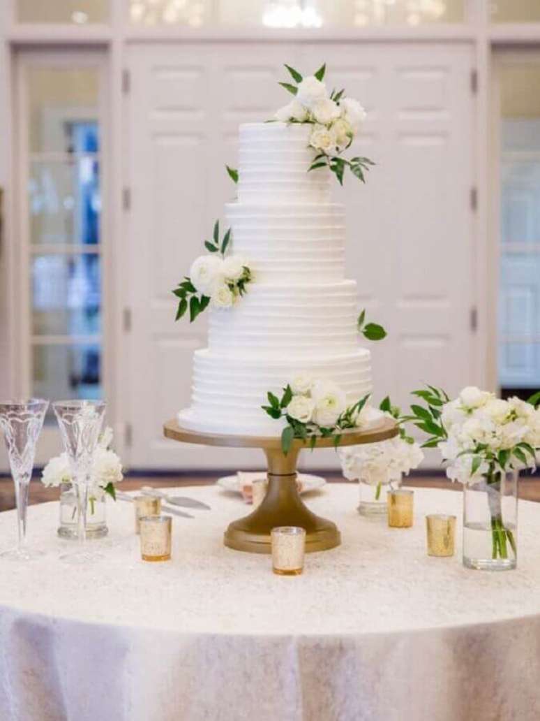 34. Modelo tradicional de bolo de casamento branco 4 andares decorado com flores brancas – Foto: Wedding Chicks