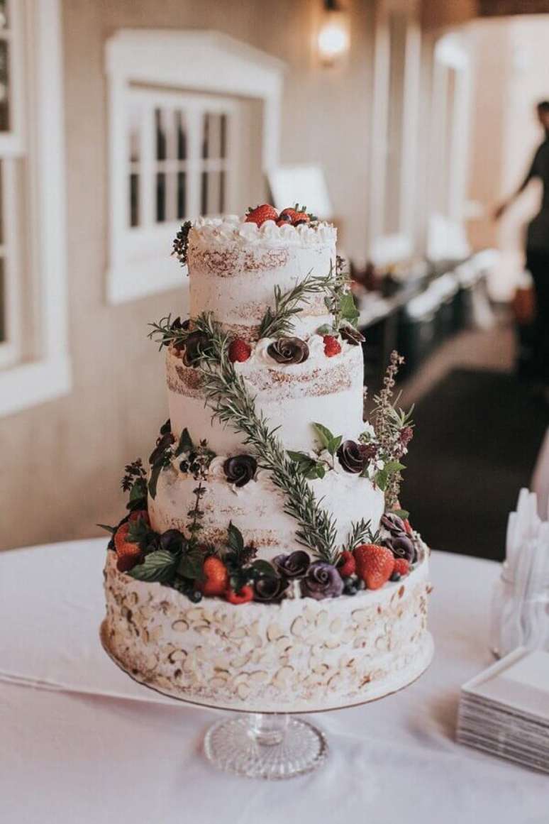 90. Frutas e pequenas rosas escuras para decoração de bolo de casamento rústico – Foto: The Knot