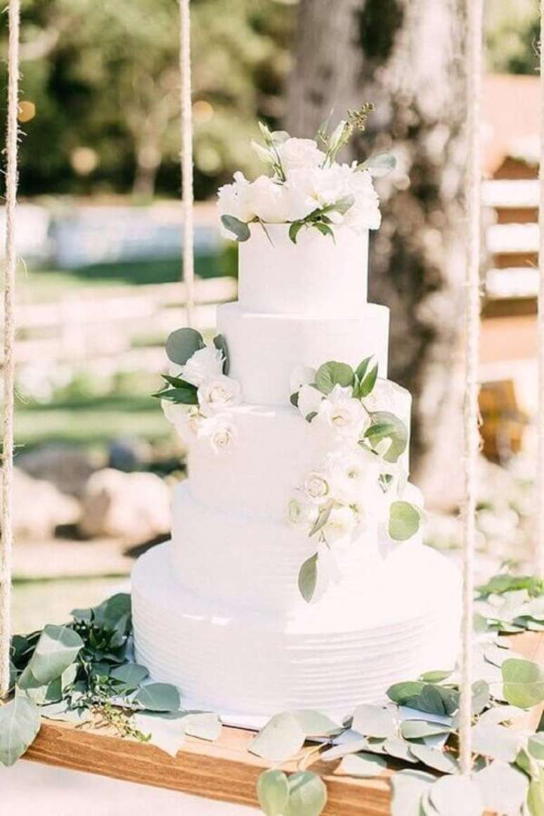 24. Lindo bolo de casamento branco decorado com folhas e flores brancas – Foto: Pinterest