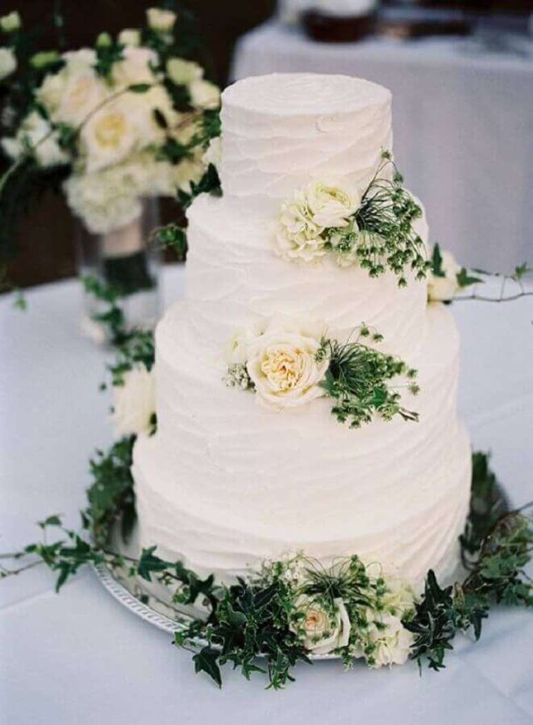 29. Bolo de casamento com chantilly decorado com folhas e flores brancas – Foto: Pinterest