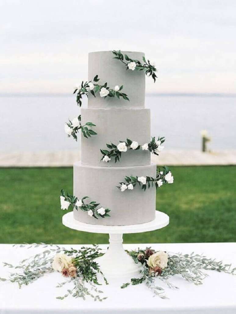 83. Decoração ao ar livre com bolo de casamento moderno decorado com flores e acabamento cinza – Foto: Weddingomania