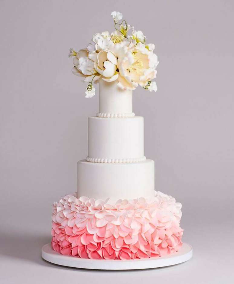 65. Bolo de casamento com flores e base cor de rosa – Foto: 100 Layer Cake