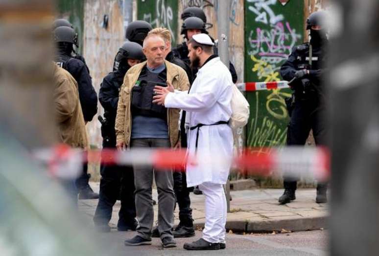 Visitante de sinagoga conversa com policiais após ataque em Halle, na Alemanha