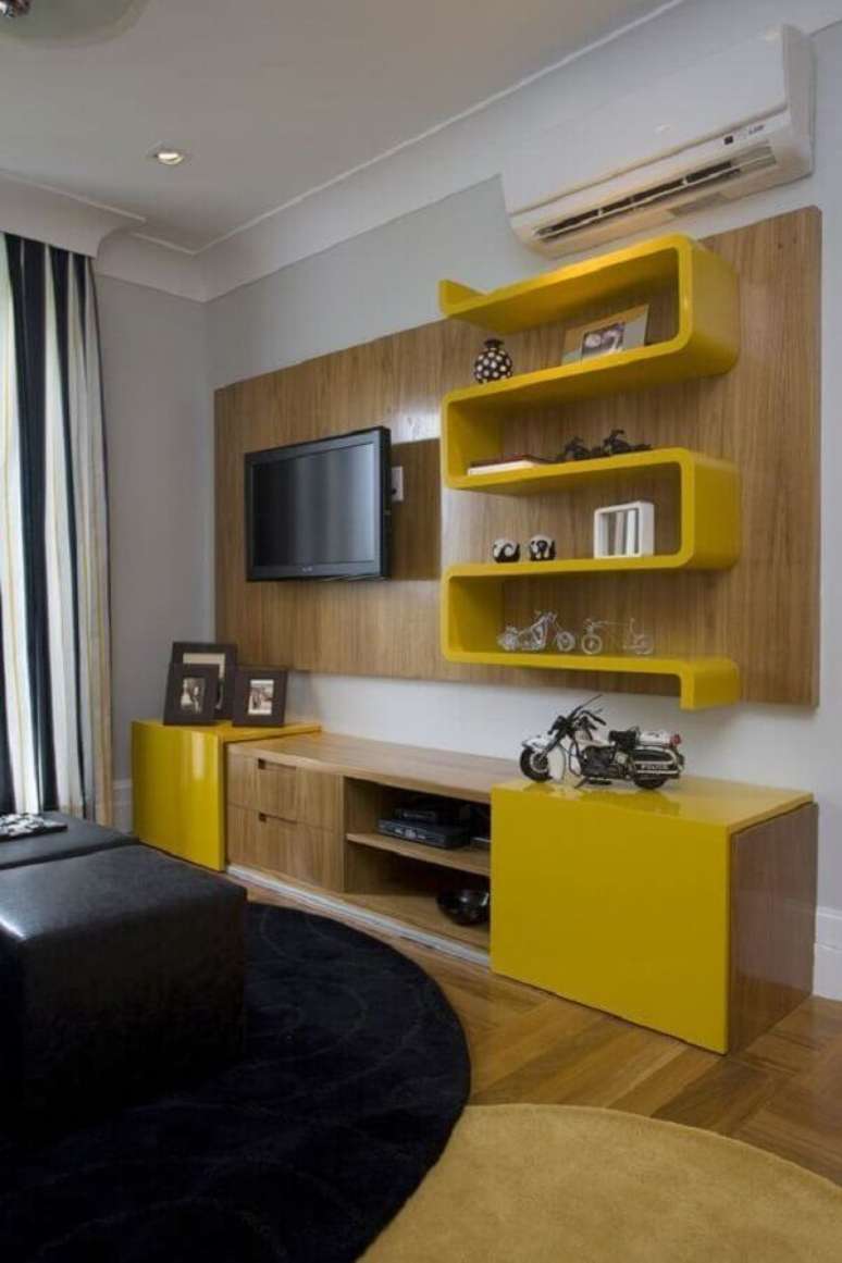 22. Rack com painel de madeira com detalhes em amarelo para decoração de sala pequena – Foto: Arquitetura do Imóvel