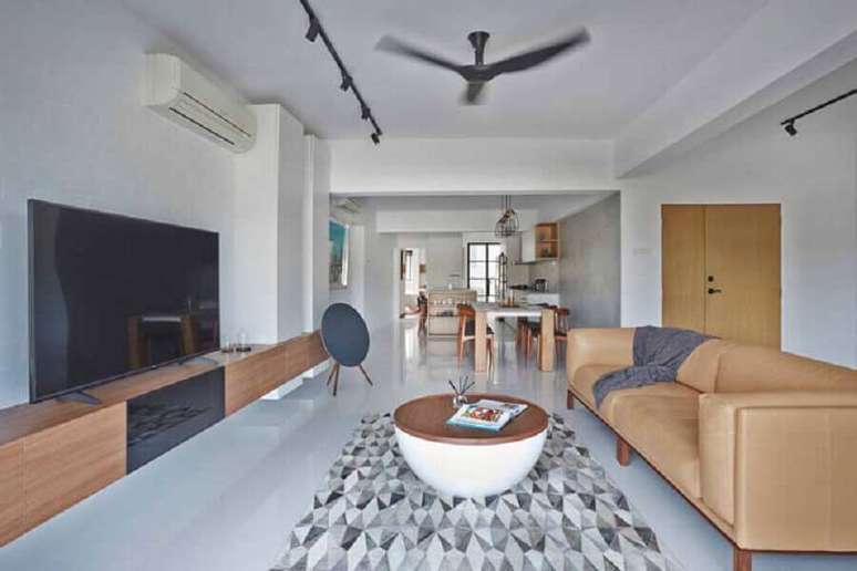 31. Sala de estar ampla decorada com sofá de couro e rack de madeira moderno – Foto: Home Design Ideas
