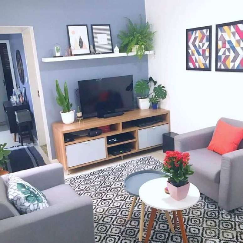 51. Sala cinza pequena decorada com mesa de centro redonda, poltronas cinza e rack de madeira simples – Foto: Blog Edge Mendes