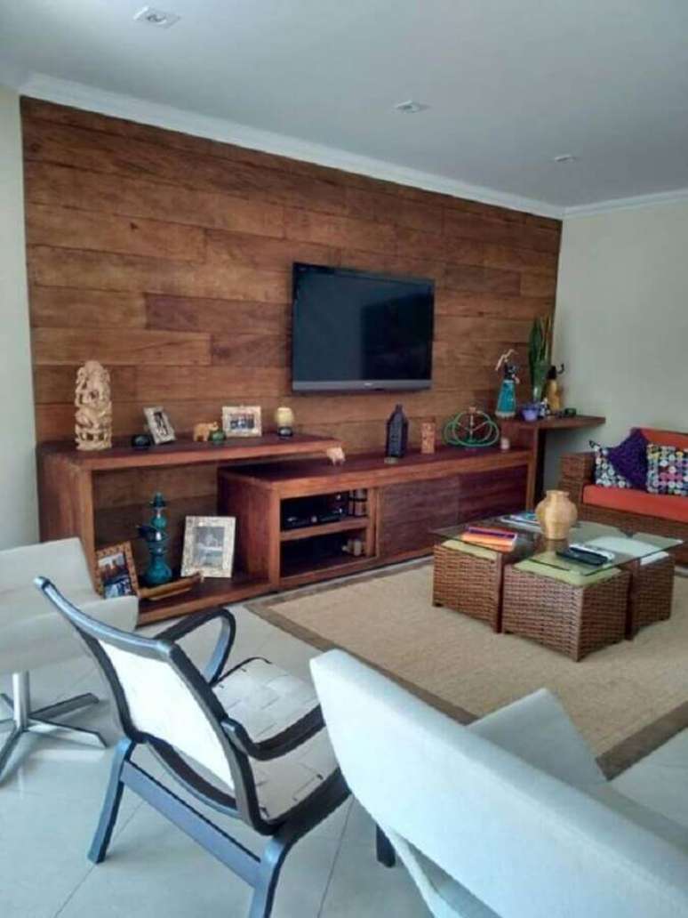 60. Rack de madeira rústica com painel para sala de estar com puff de vime – Foto: MM Representações