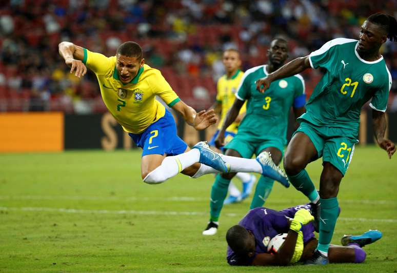 Richarlison em disputa de bola com Lamine Gassama em amistoso contra o Senegal, em Cingapura 10/10/2019  REUTERS/Feline Lim