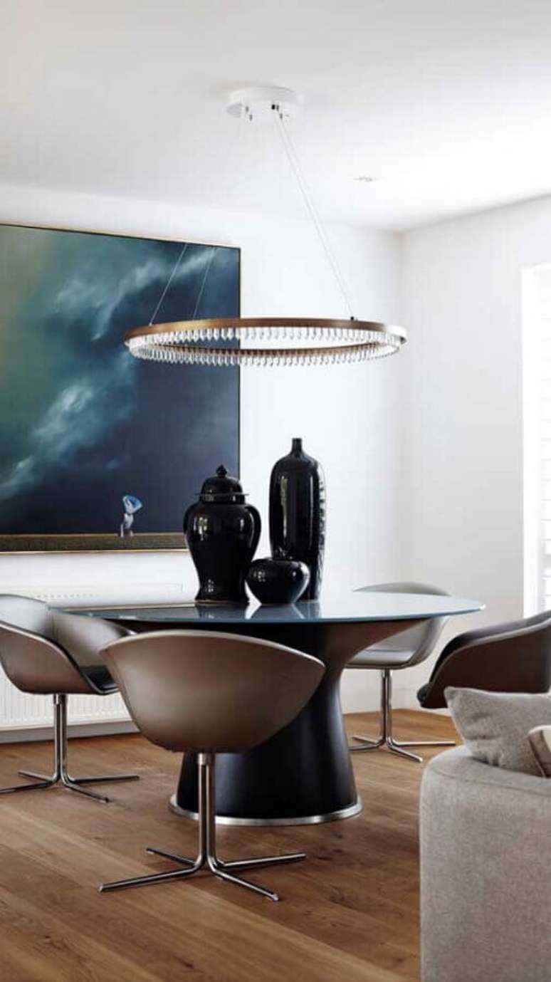 9. Sala de jantar moderna decorada com mesa redonda e cadeira de jantar girat&oacute;ria &ndash; Foto: Assetproject