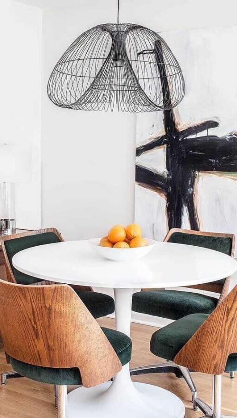 56. Mesa redonda branca com cadeira de jantar giratória de madeira – Foto: Ideias Decor