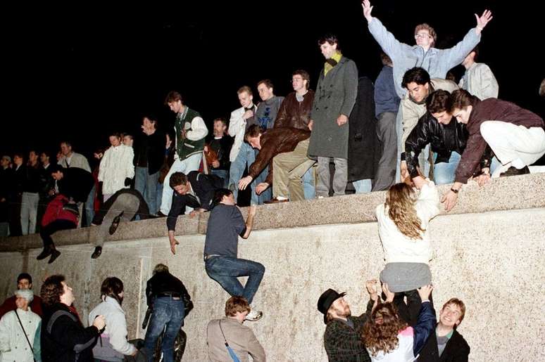 Moradores de Berlim Oriental escalaram o Muro em 9 de novembro de 1989, derrubando a Cortina de Ferro na Alemanha