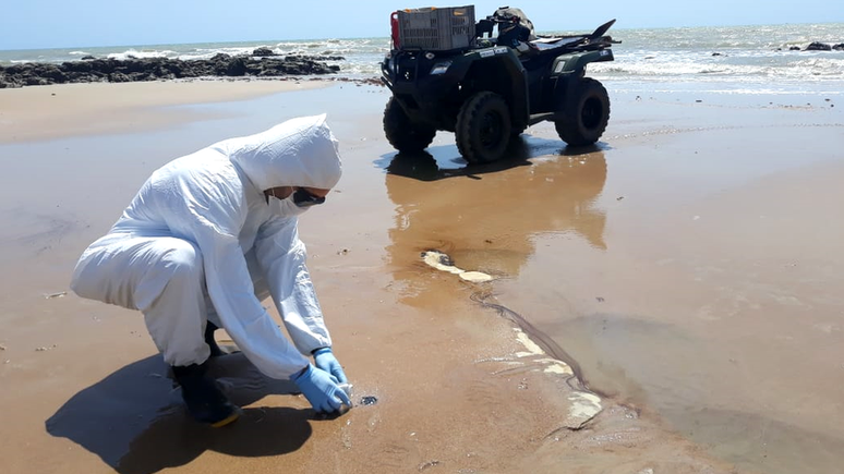 Biólogo colhe amostra de petróleo em praia no Rio Grande do Norte