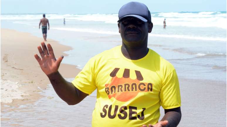 Barraqueiro Valdir Carvalho, que há oito anos mantém seu ponto na Praia do Flamengo, em Salvador, arrisca-se pegando as pelotas de óleo sem qualquer proteção