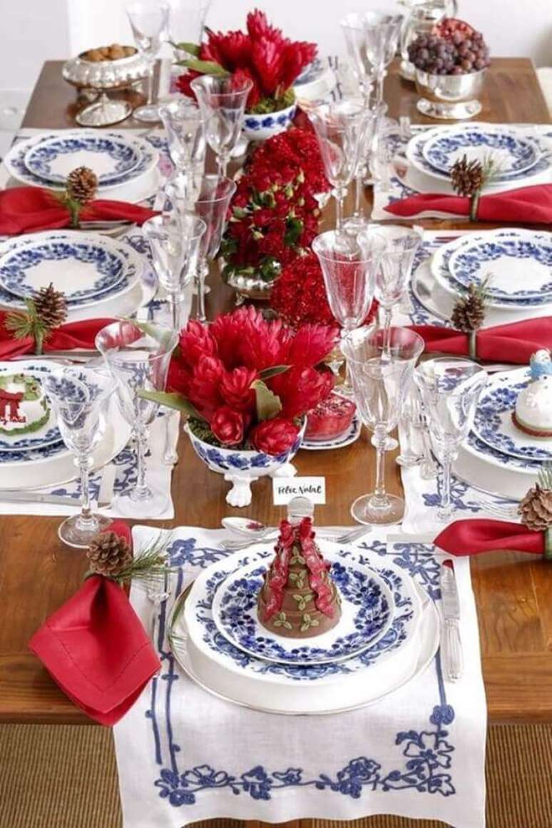 31. Decoração para mesa de natal com flores vermelhas e louças estampas azuis – Foto: Fashion Submarine