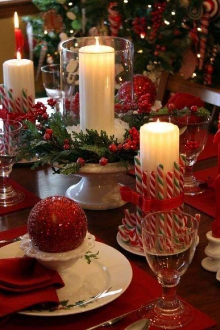 41. Decoração com arranjos de natal com velas e bolas vermelhas – Foto: Thiago Calil decor
