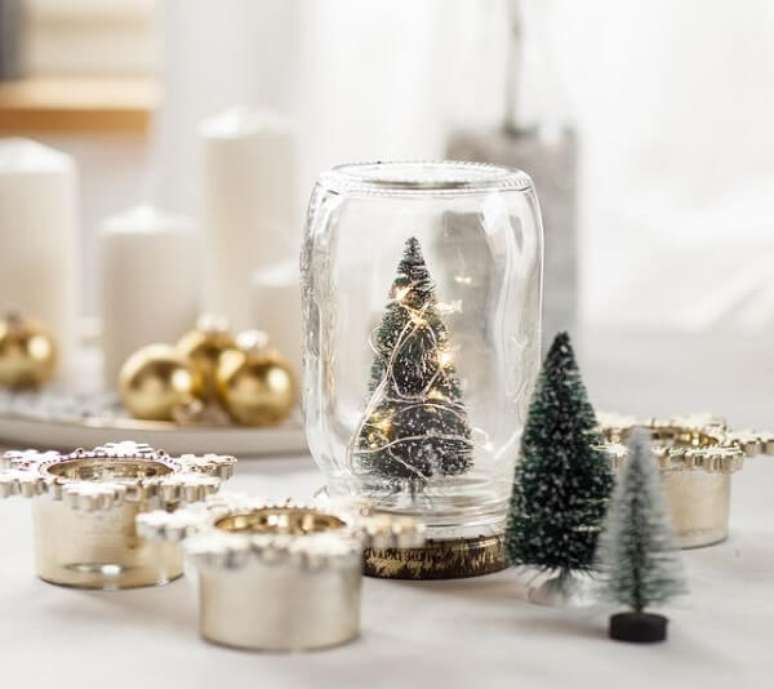 82. Arranjos de Natal feitos feitos com pote de vidro, velas e mini árvore – Fonte: Pinterest