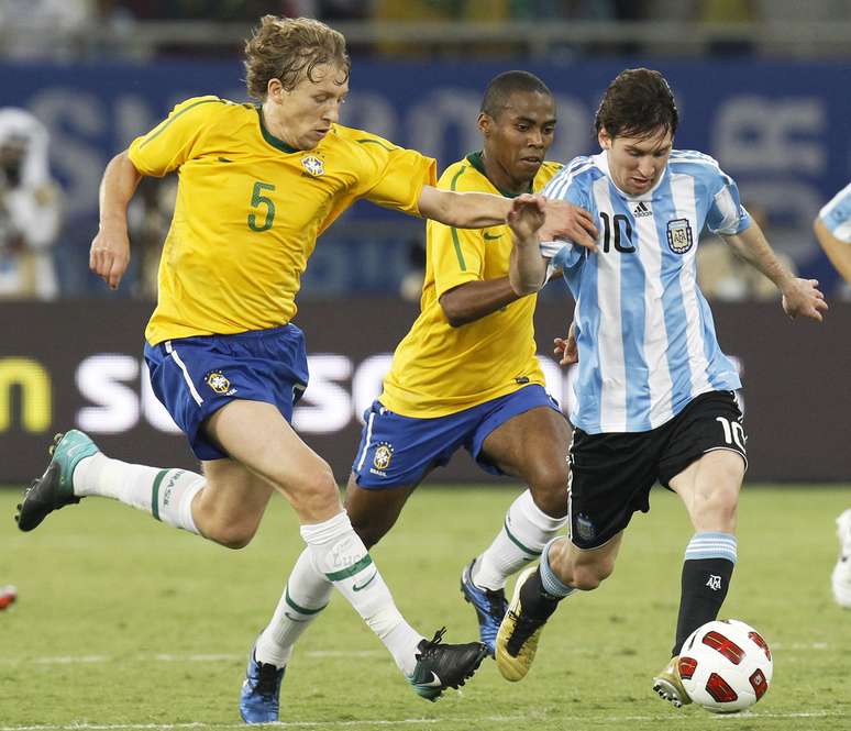 Lionel Messi dribla jogadores brasileiros em confronto entre Argentina e Brasil, em Doha, no Catar (17/11/2010)