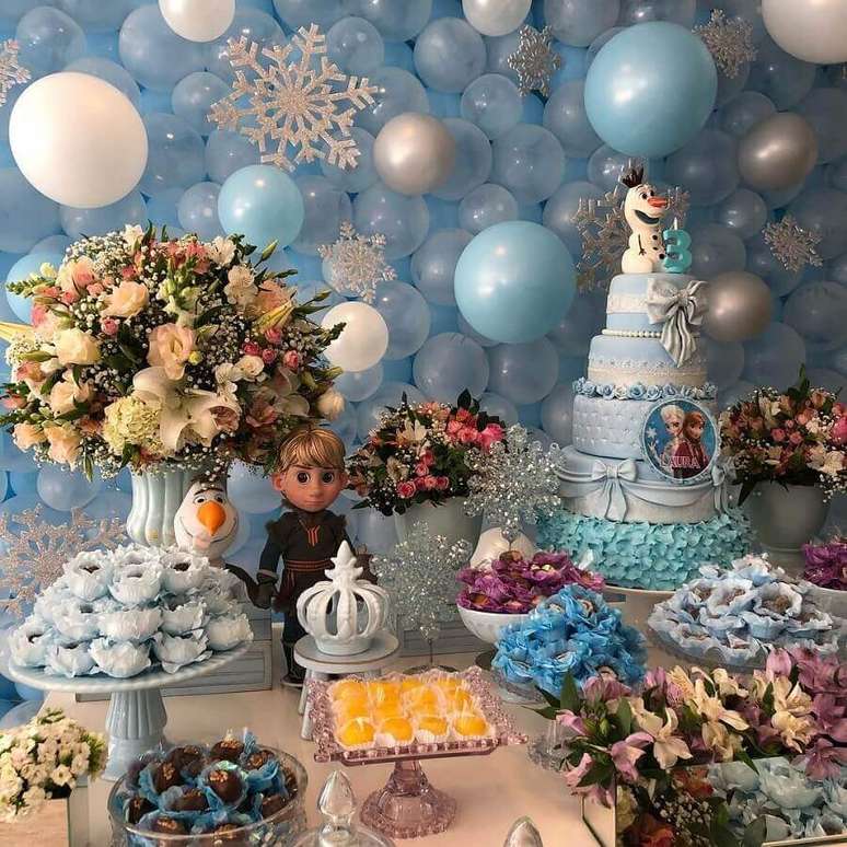 38. Linda decoração de mesa de festa infantil da Frozen com arranjo de flores e painel com balões – Foto: Fantastique by Bárbara Brant