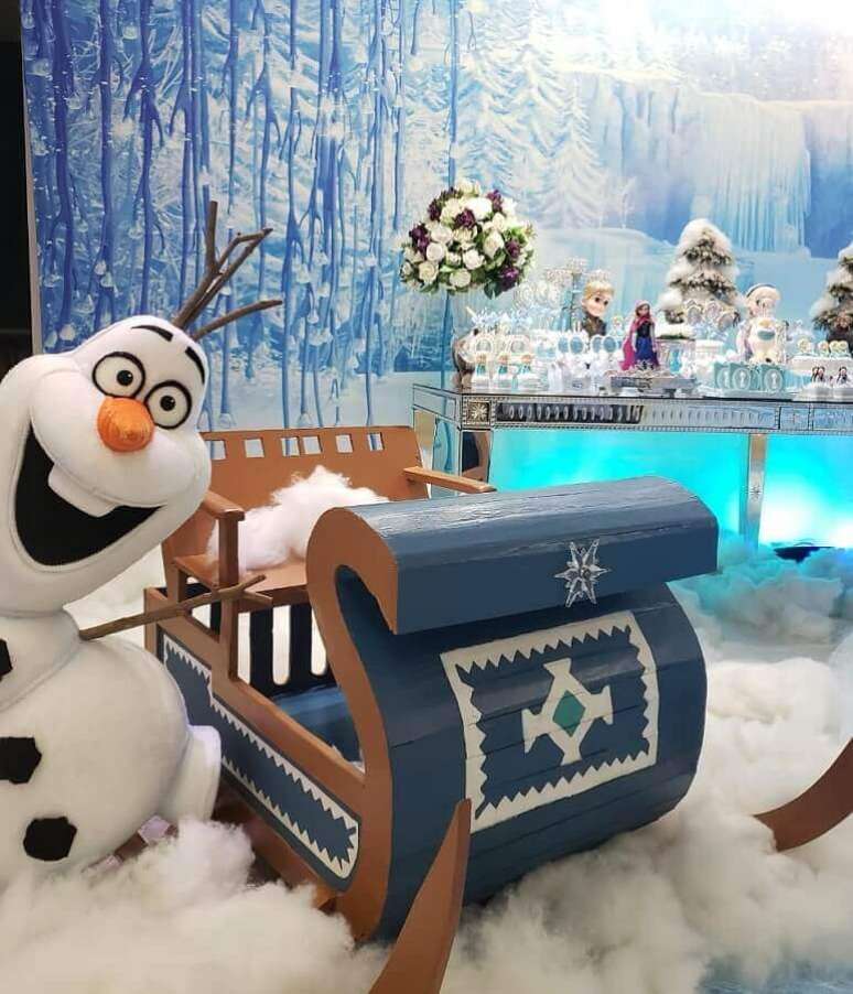 39. Decoração de festa de aniversário da Frozen com boneco de neve grande e trenó de madeira – Foto: Naty e Cia