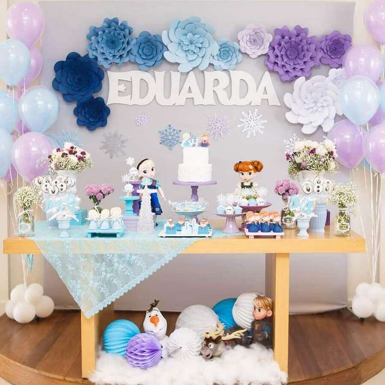 58. Festa da Frozen simples decorada com balões azul e lilás e flores de papel – Foto: Arquiteta Party Decor