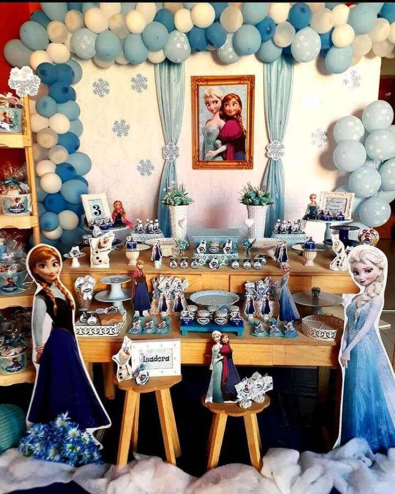 70. Detalhes rústicos com móveis de madeira para festa da Frozen simples decorada com balões azuis e brancos – Foto: Macherry Mimos
