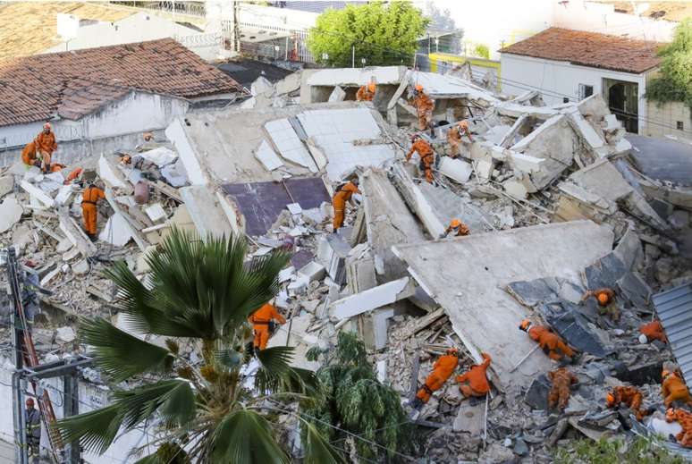 Agentes do Corpo de Bombeiros do Ceará trabalhando nos escombros do prédio que desabou na manhã desta terça-feira.