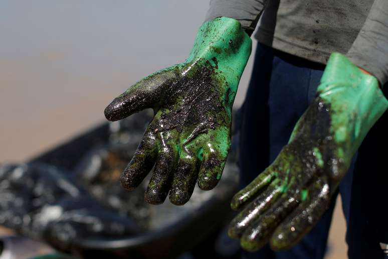 Trabalho de limpeza de manchas de óleo na praia de Coruripe, Alagoas 14/10/2019 REUTERS/Adriano Machado