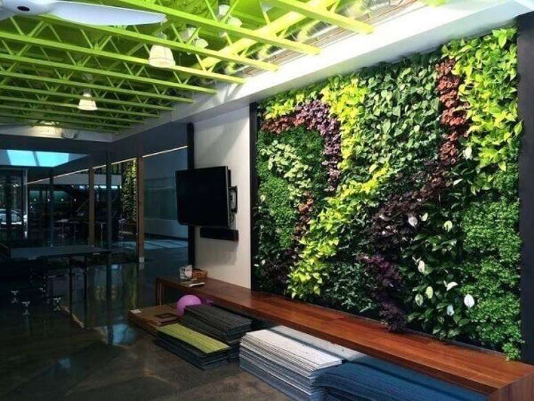 16. Os tons de verde do jardim vertical artificial se harmonizam com a cor do teto. Fonte: Pinterest