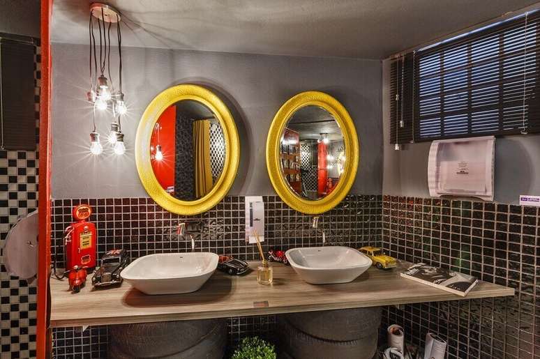 10. Decoração com estilo industrial para banheiro cinza com madeira na bancada e espelhos com moldura amarela – Foto: Lídici Melo