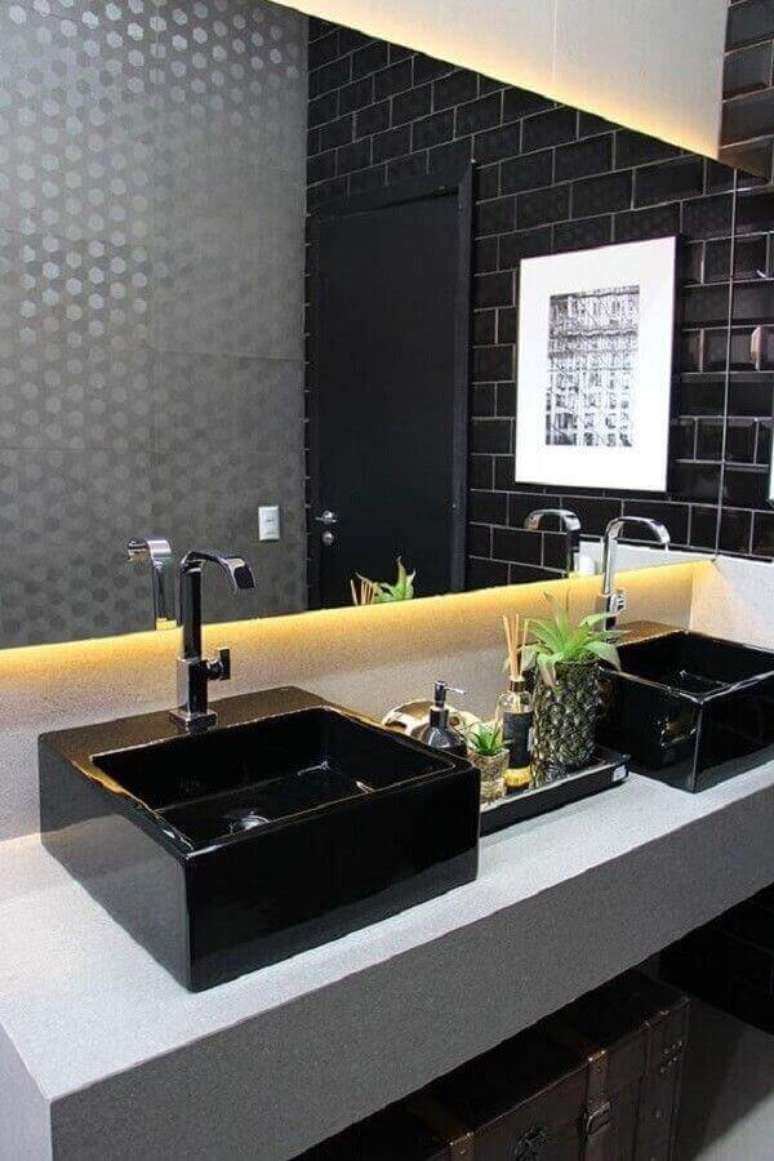 5. Banheiro preto e cinza moderno decorado com iluminação embutida atrás do espelho – Foto: Revista VD