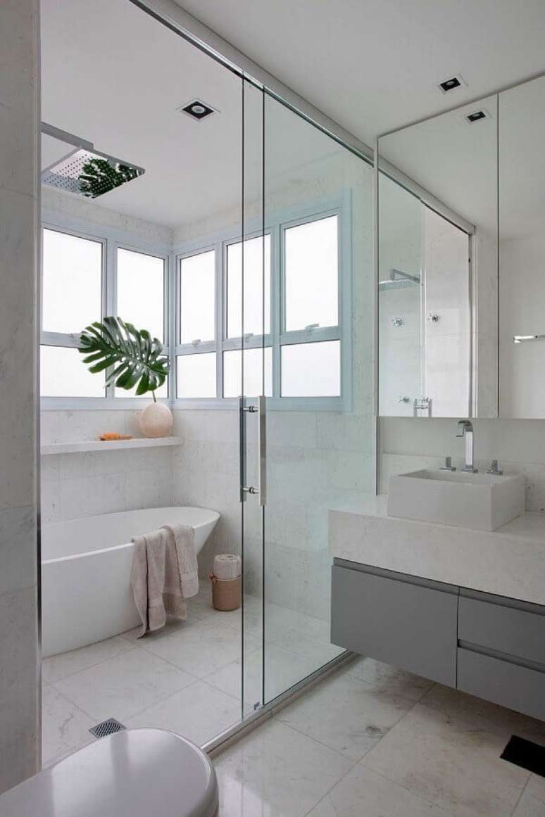 24. Decoração clean com gabinete para banheiro cinza e branco com banheira pequena – Foto: Casa de Valentina
