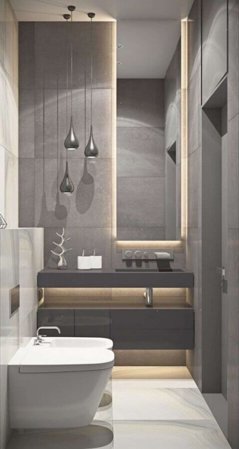 35. Banheiro cinza pequeno com decoração moderna e iluminação embutida atrás do espelho – Foto: Pinterest