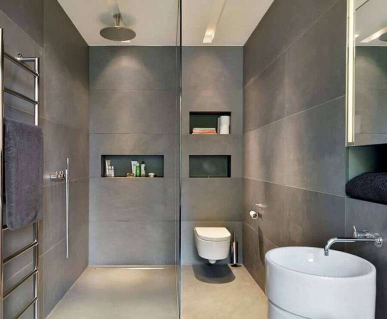 42. Decoração moderna para banheiro cinza com nichos embutidos e pia redonda – Foto: Pinosy