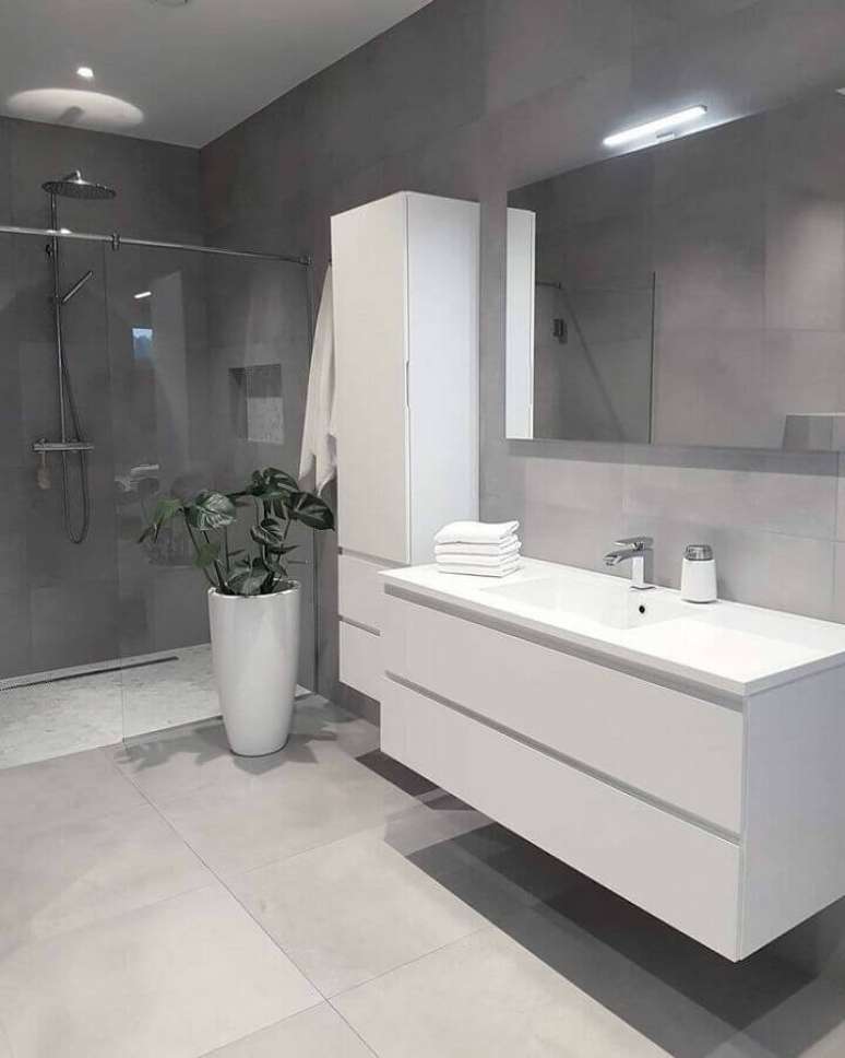 44. Decoração clean com revestimento cinza para banheiro com gabinete branco – Foto: Pinterest