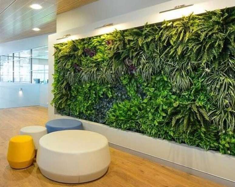 25. Escritório com parede revestida por um jardim vertical artificial traz aconchego aos funcionários. Fonte: Pinterest