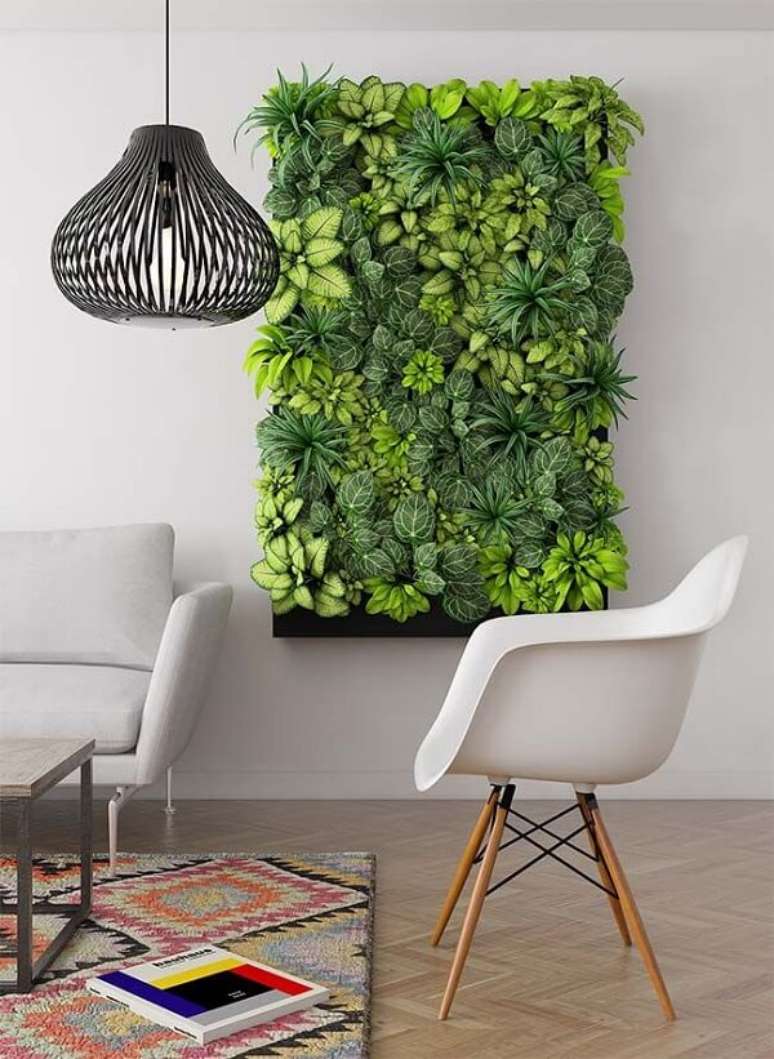 42. O tom verde do jardim vertical artificial traz alegria para a decoração da sala de estar. Fonte: Pinterest